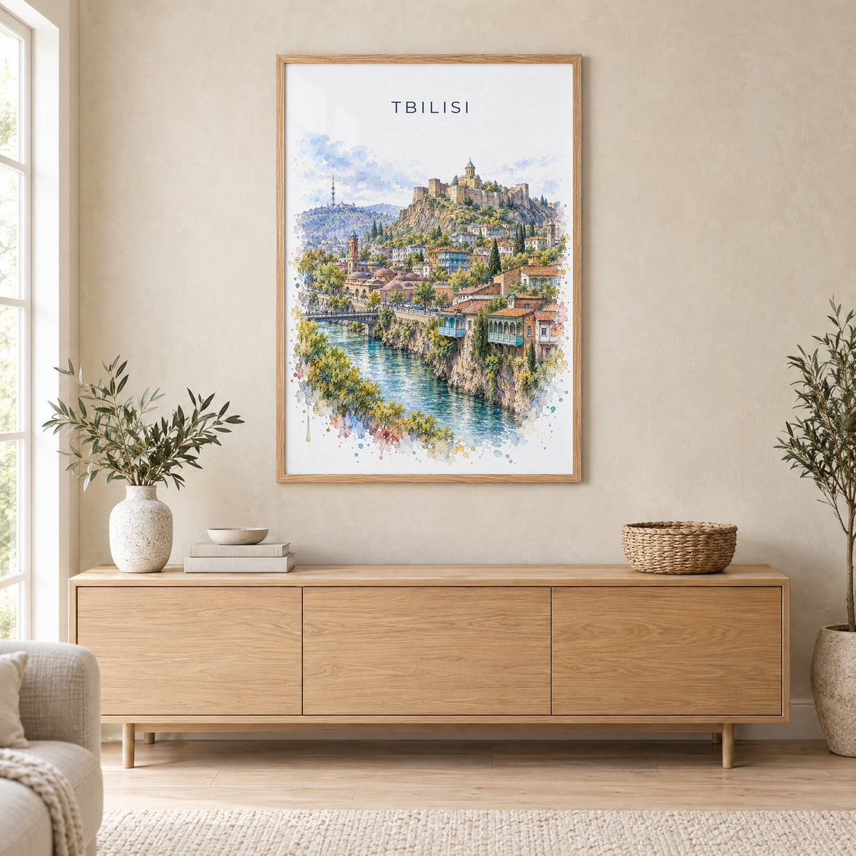 Tbilisi watercolor print in an oak frame above a light wood sideboard in a Scandinavian living room