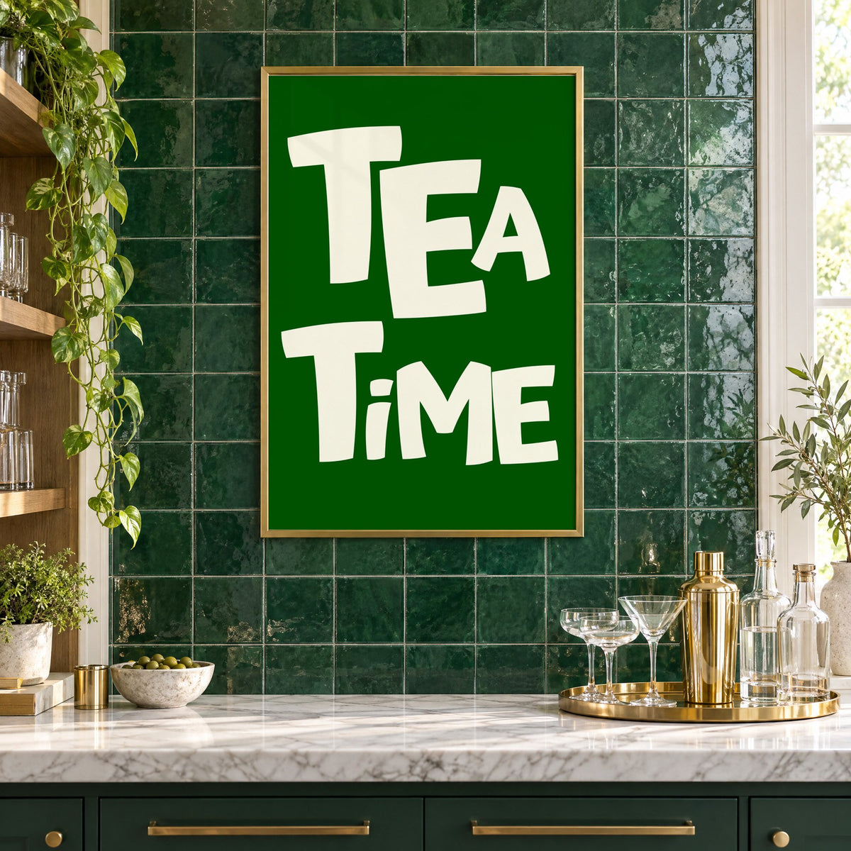 TEA TiME green typography print in a brass frame on emerald green tiles above a home bar with coupe glasses