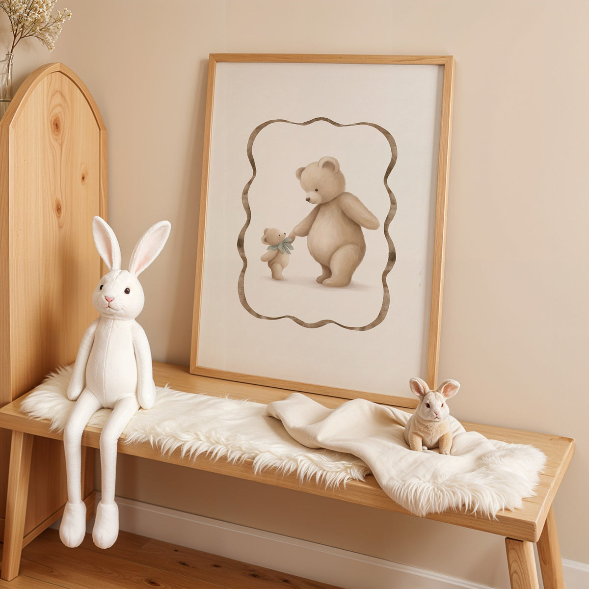 Big and little teddy bears holding hands nursery print in an oak frame on a sheepskin bench beside a white plush bunny