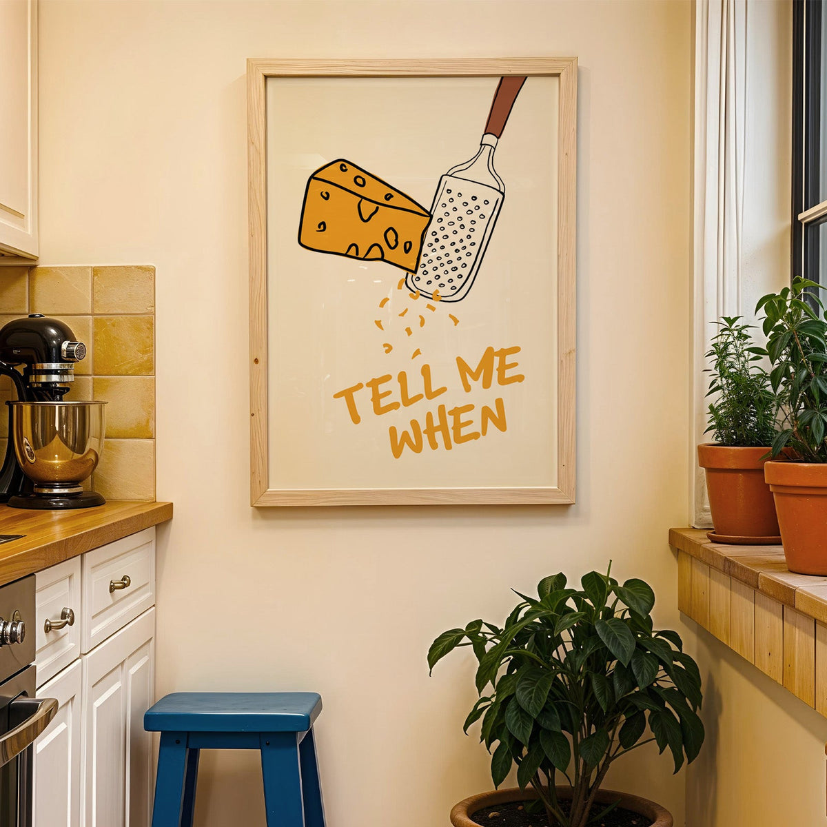 Tell me when cheese grater print in a wood frame on a yellow tiled kitchen wall