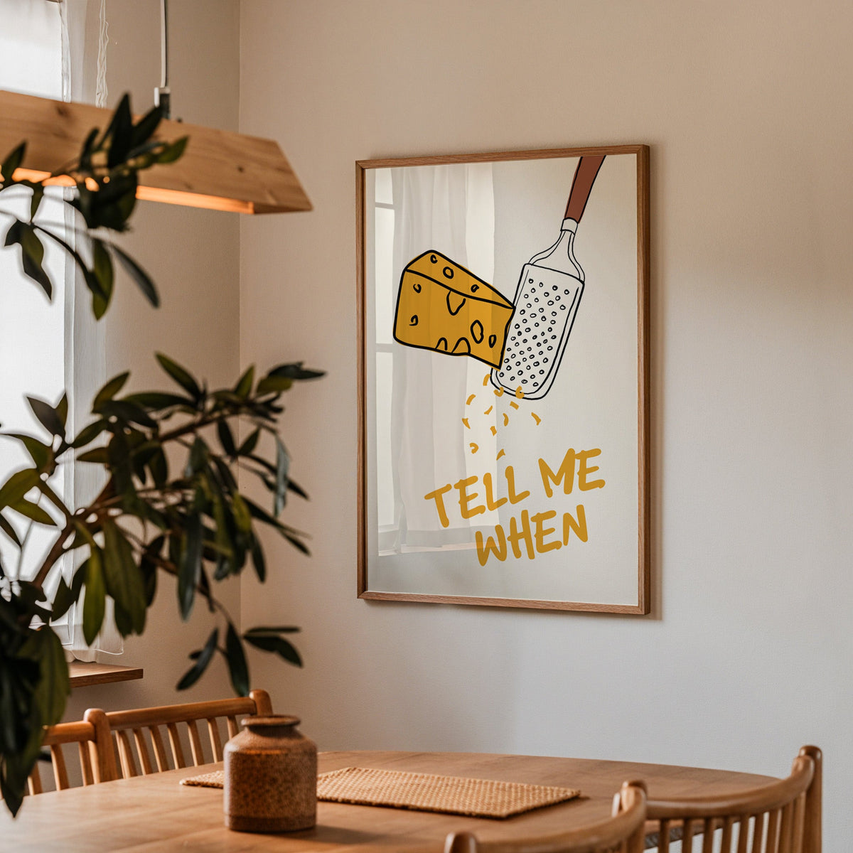 Tell me when cheese grater print in a walnut frame above a table beside an olive tree