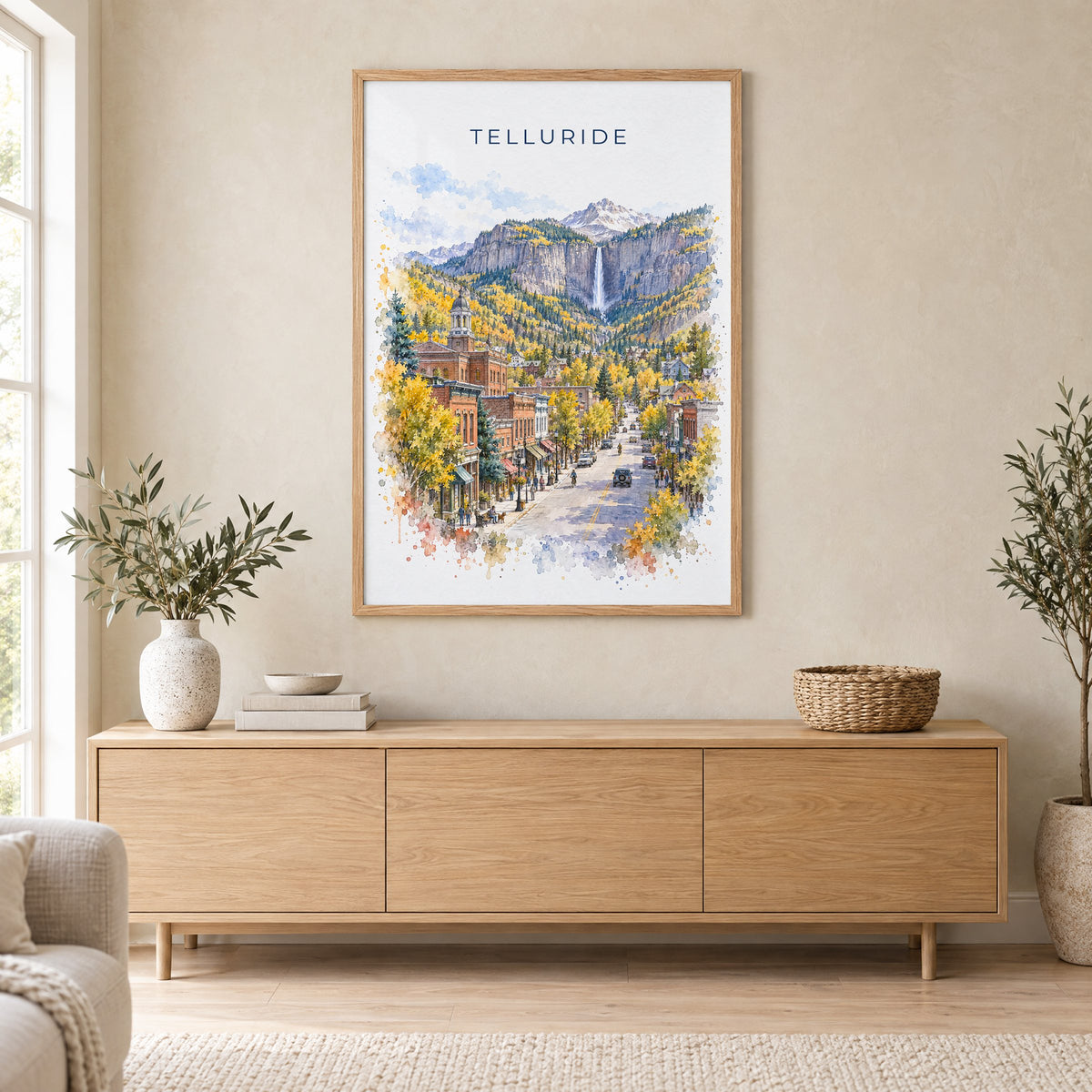 Telluride watercolor print in an oak frame above a light wood sideboard in a Scandinavian living room