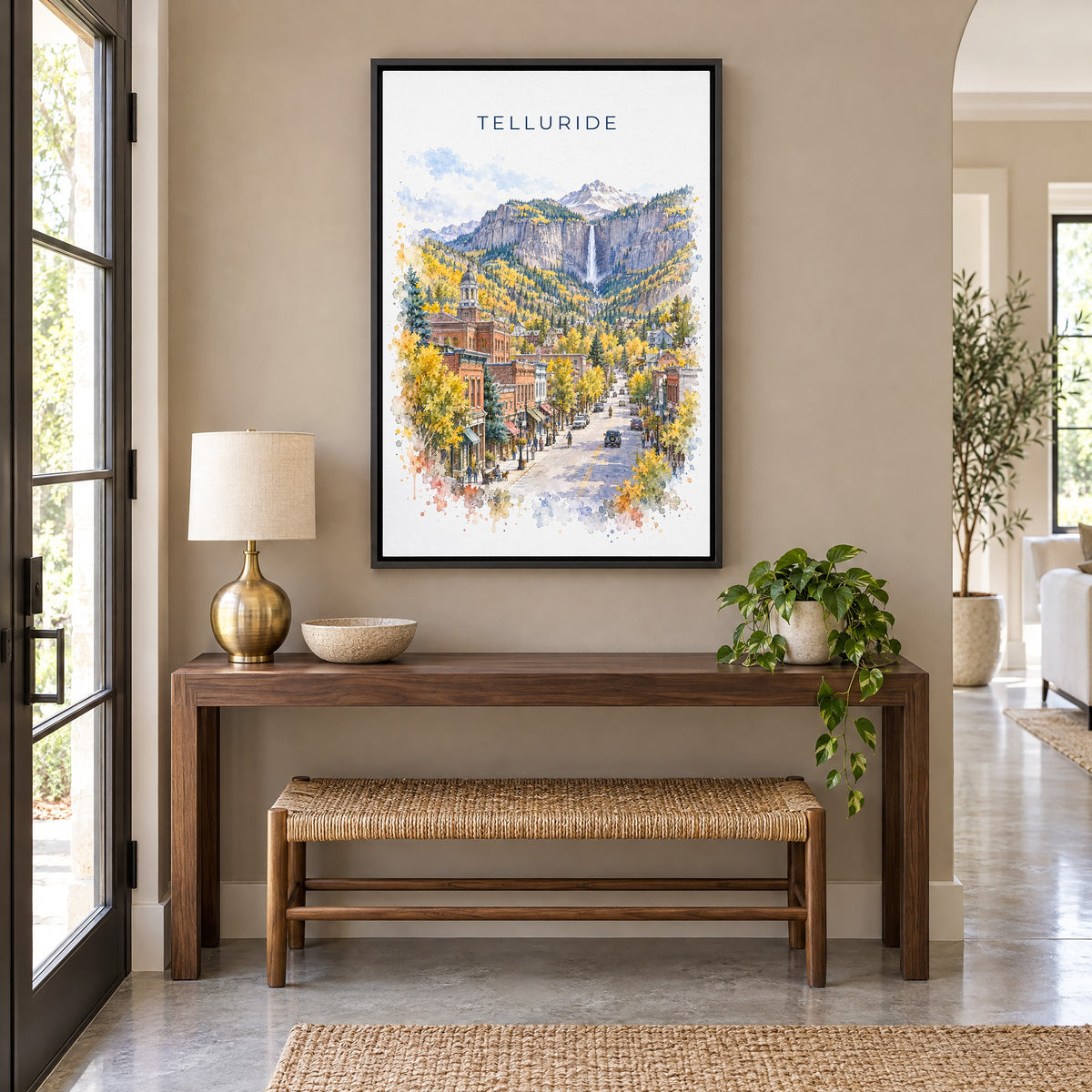 Telluride watercolor print as a black floater canvas above a walnut console and woven bench in an entryway
