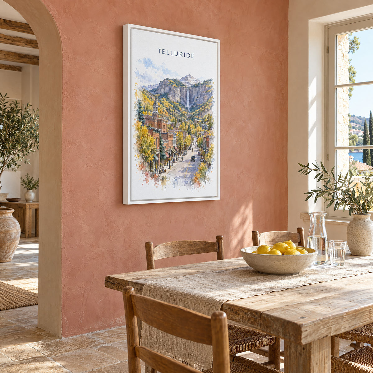 Telluride watercolor print as a white floater canvas on a terracotta wall above a rustic dining table