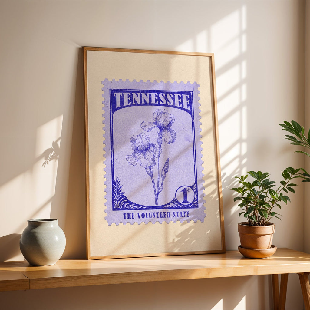 Tennessee Iris stamp print in a light oak frame leaning on a wooden table beside a stoneware vase