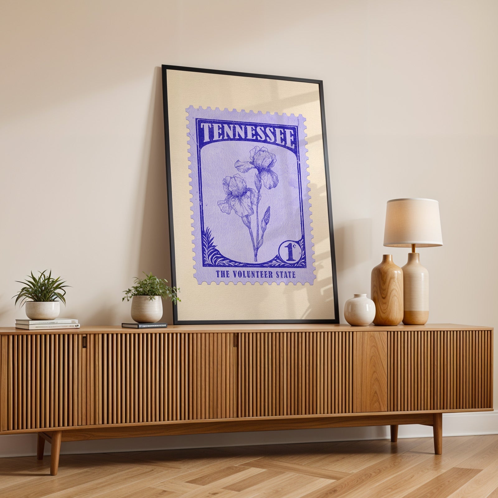 Tennessee state flower print in a black frame leaning on a fluted wood credenza with vases and a lamp