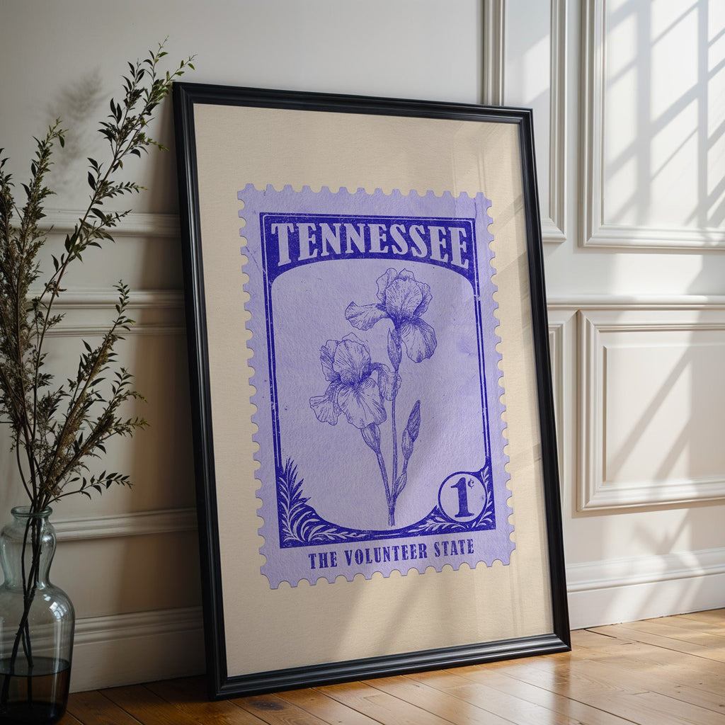 Tennessee state flower print in a black frame leaning against a white panelled wall beside olive branches