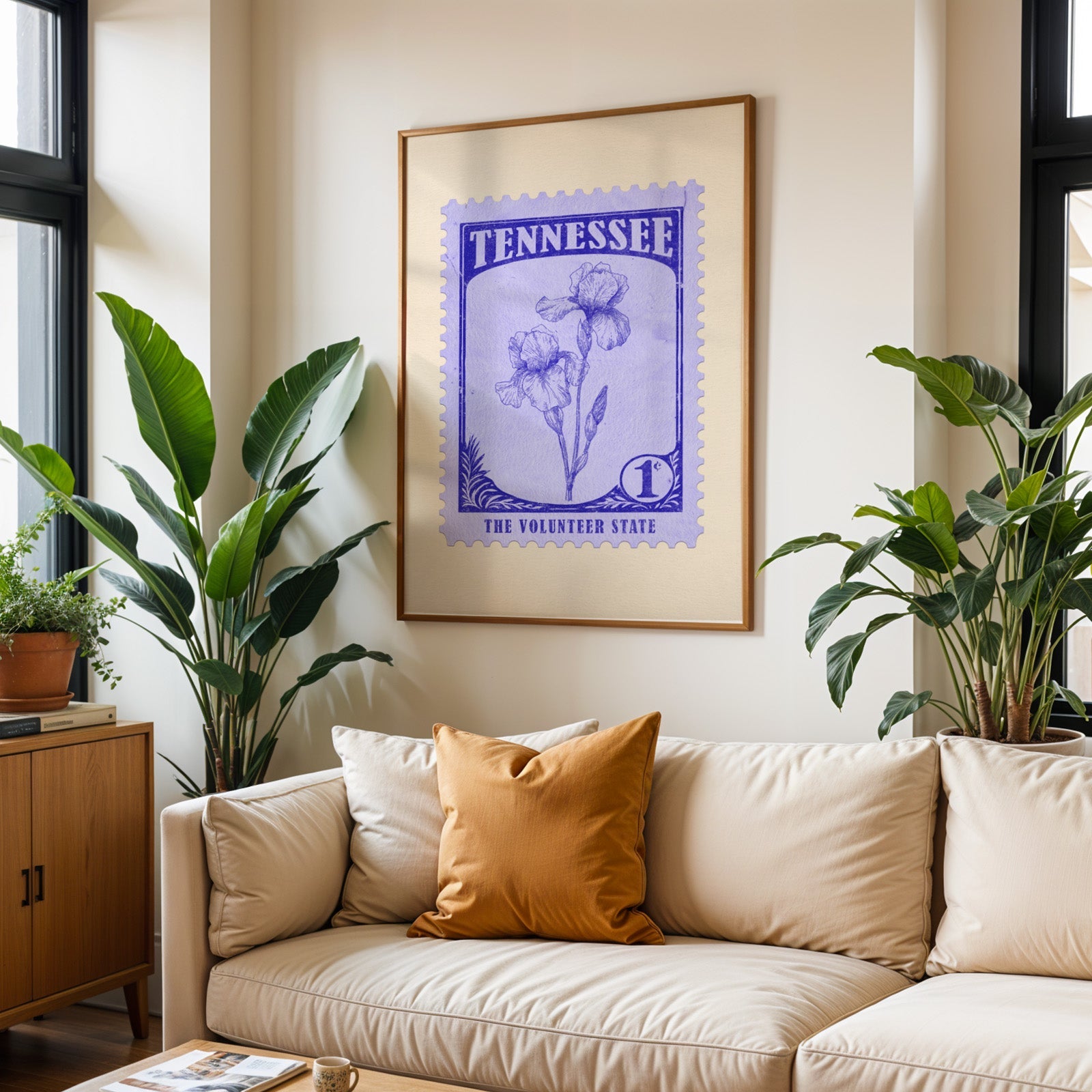 Tennessee state flower print framed above a cream sofa with an ochre cushion and large plants either side