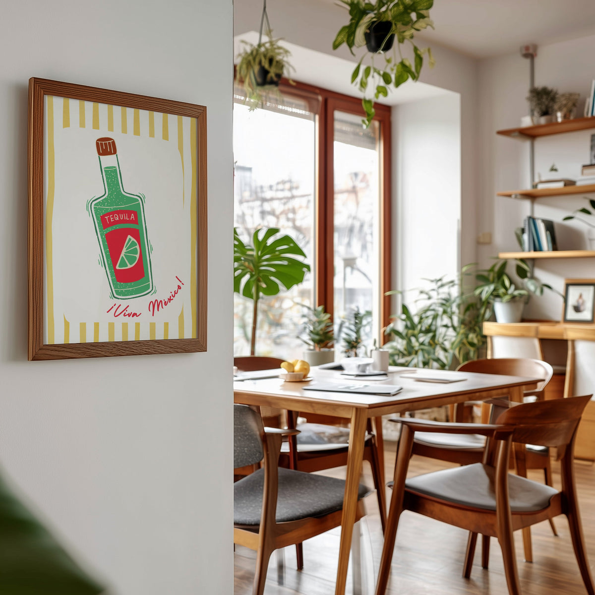 Tequila bottle print in a walnut frame beside a mid-century dining table