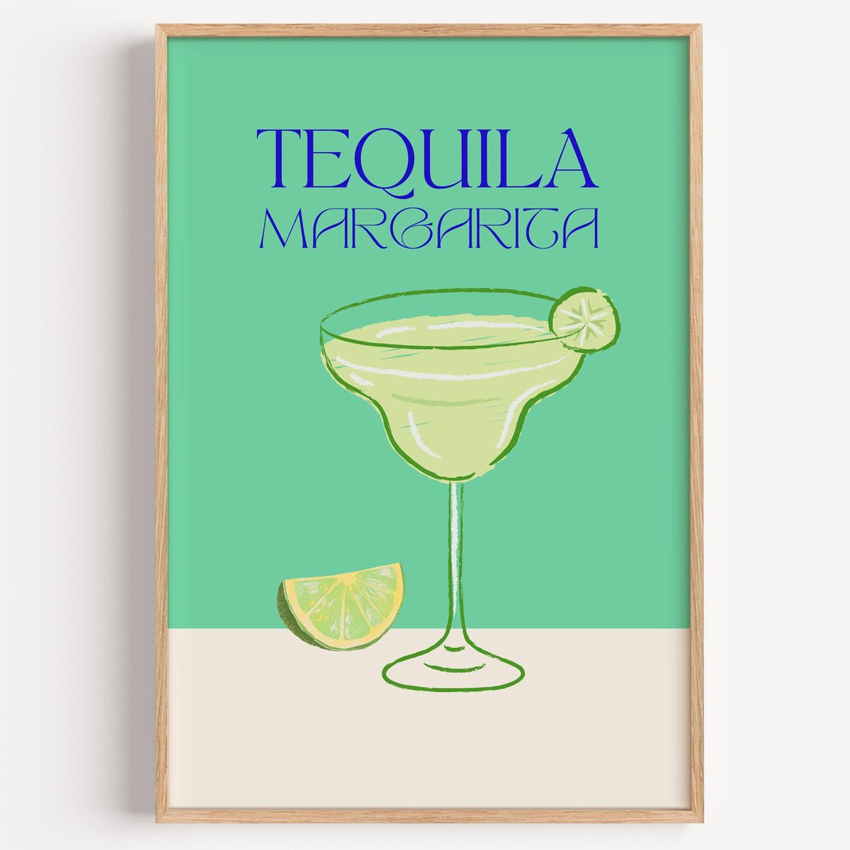 TEQUILA MARGARITA green glass and lime print in a light oak frame on a plain white wall