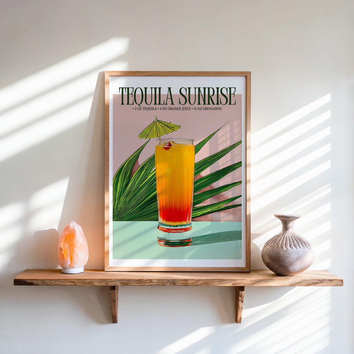Tequila sunrise recipe print in an oak frame on a live-edge shelf beside a salt lamp