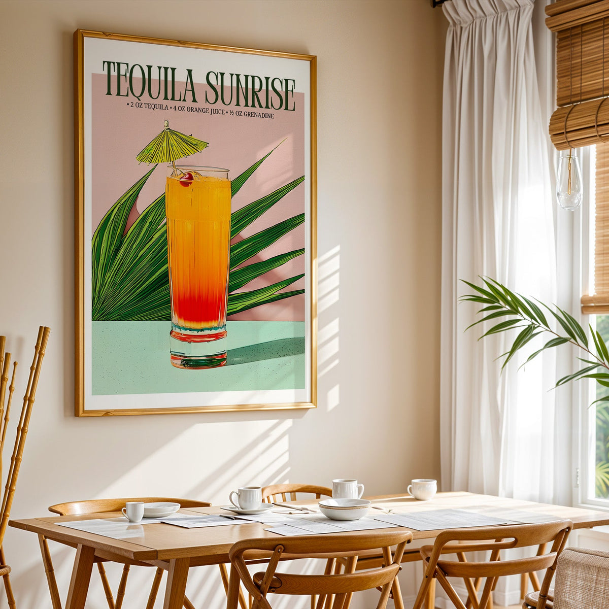 Tequila sunrise recipe print shown in a gold frame above a breakfast table by a curtained window