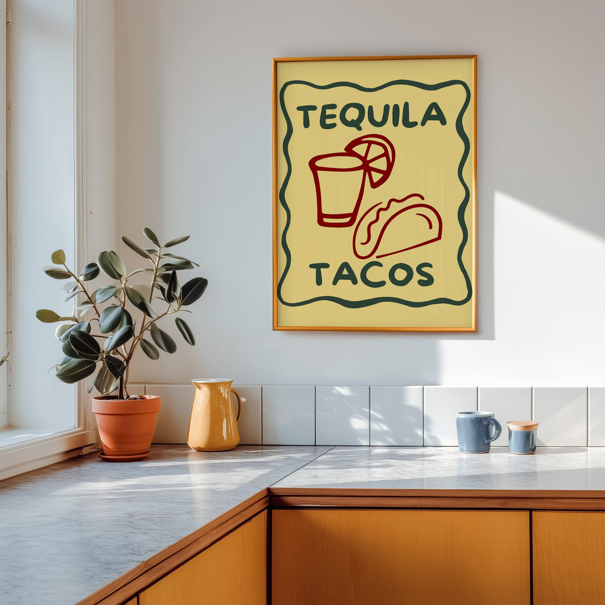 Tequila Tacos print shown in a gold frame above a marble counter in a tan kitchen