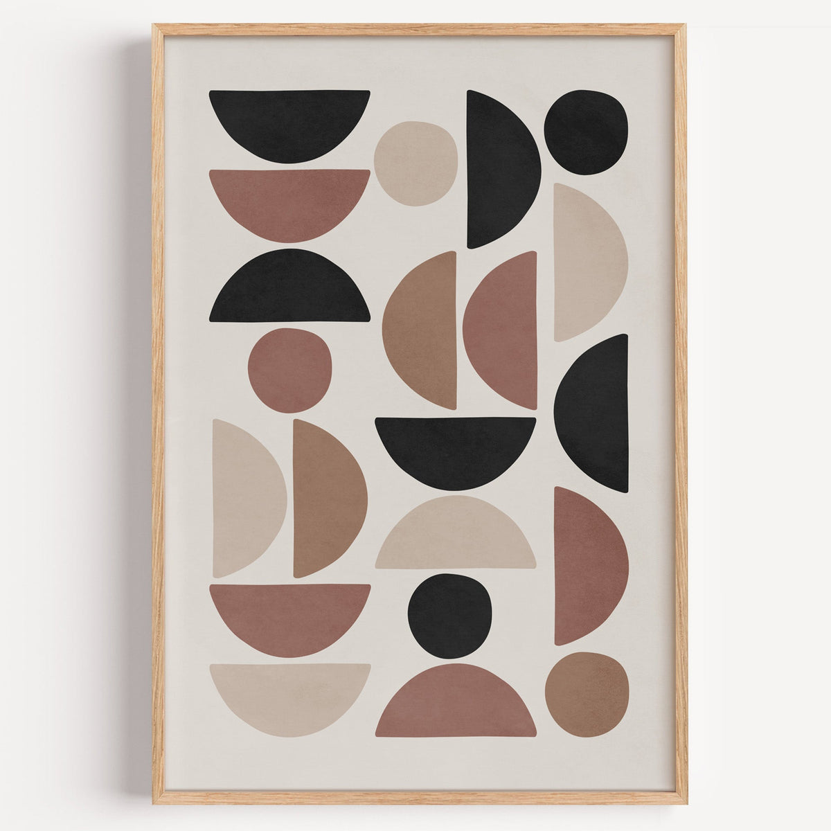 Terracotta and black half circle mosaic print in a light oak frame on a plain white wall