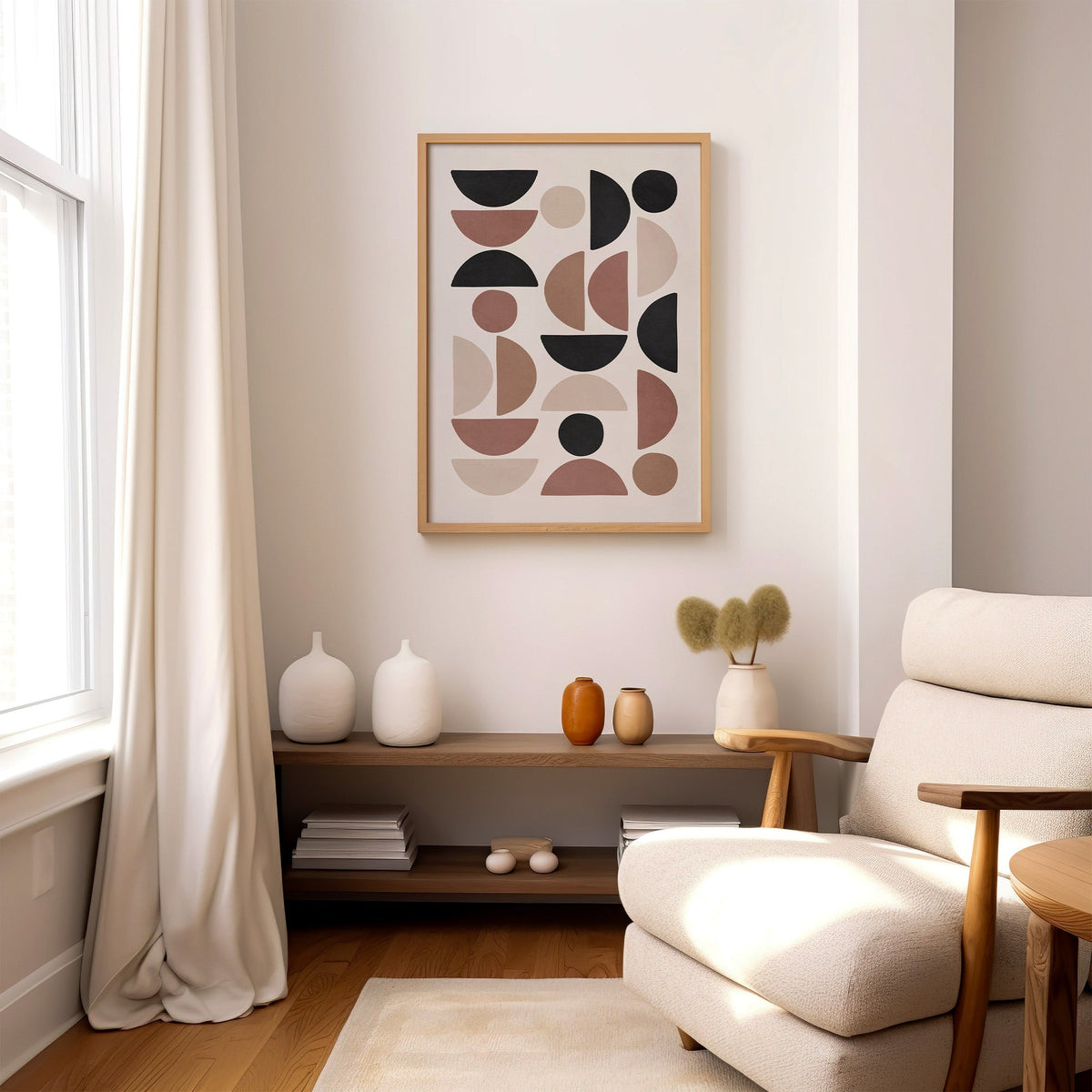 Terracotta and black half circle mosaic print in an oak frame above a wood console shelf by a cream boucle armchair