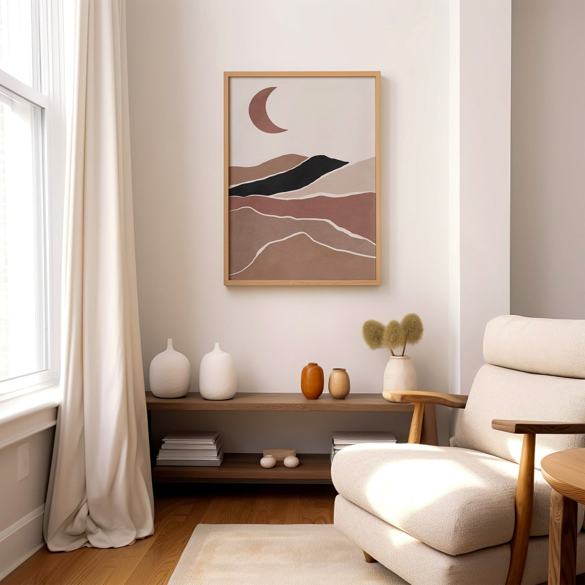 Terracotta crescent moon over hills boho print in an oak frame above a wood console shelf by a cream boucle armchair