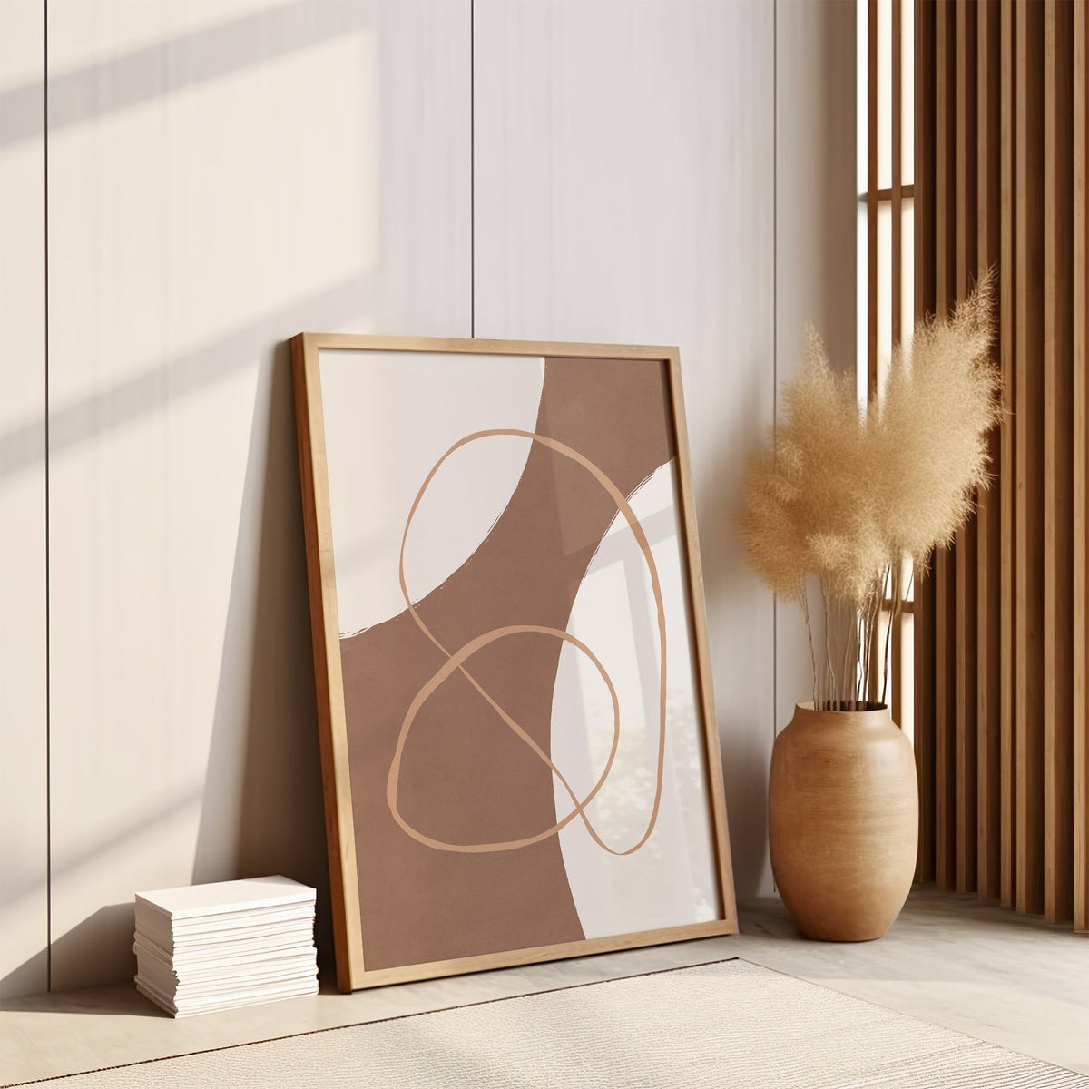 Terracotta curved band and loop line art print in an oak frame leaning on the floor by pampas grass and a wood slat screen