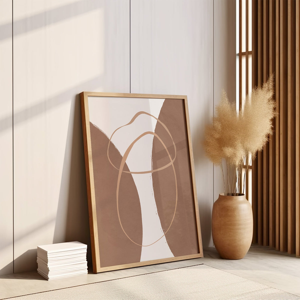 Terracotta twin arches and loops boho print in an oak frame leaning on the floor by pampas grass and a wood slat screen