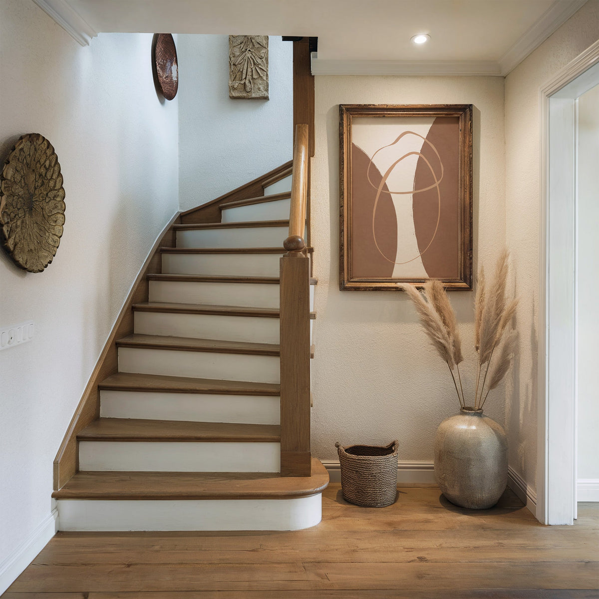 Terracotta twin arches and loops boho print shown in a rustic wood frame in a hallway beside a wooden staircase