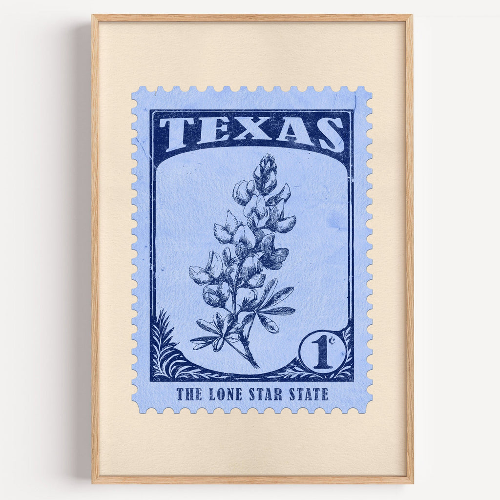 Texas state flower stamp print in navy on light blue, light oak frame on a plain white wall