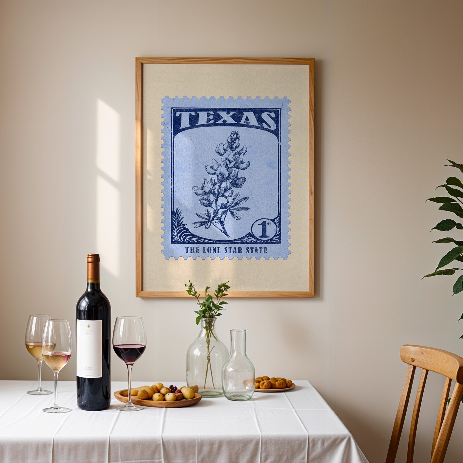 Texas stamp print framed on the wall above a dining table set with wine, glasses and olives