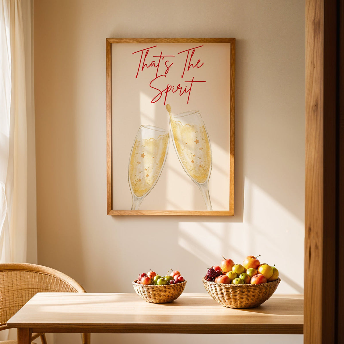 Thats the Spirit champagne flutes print in an oak frame above a light wood dining table with baskets of fruit