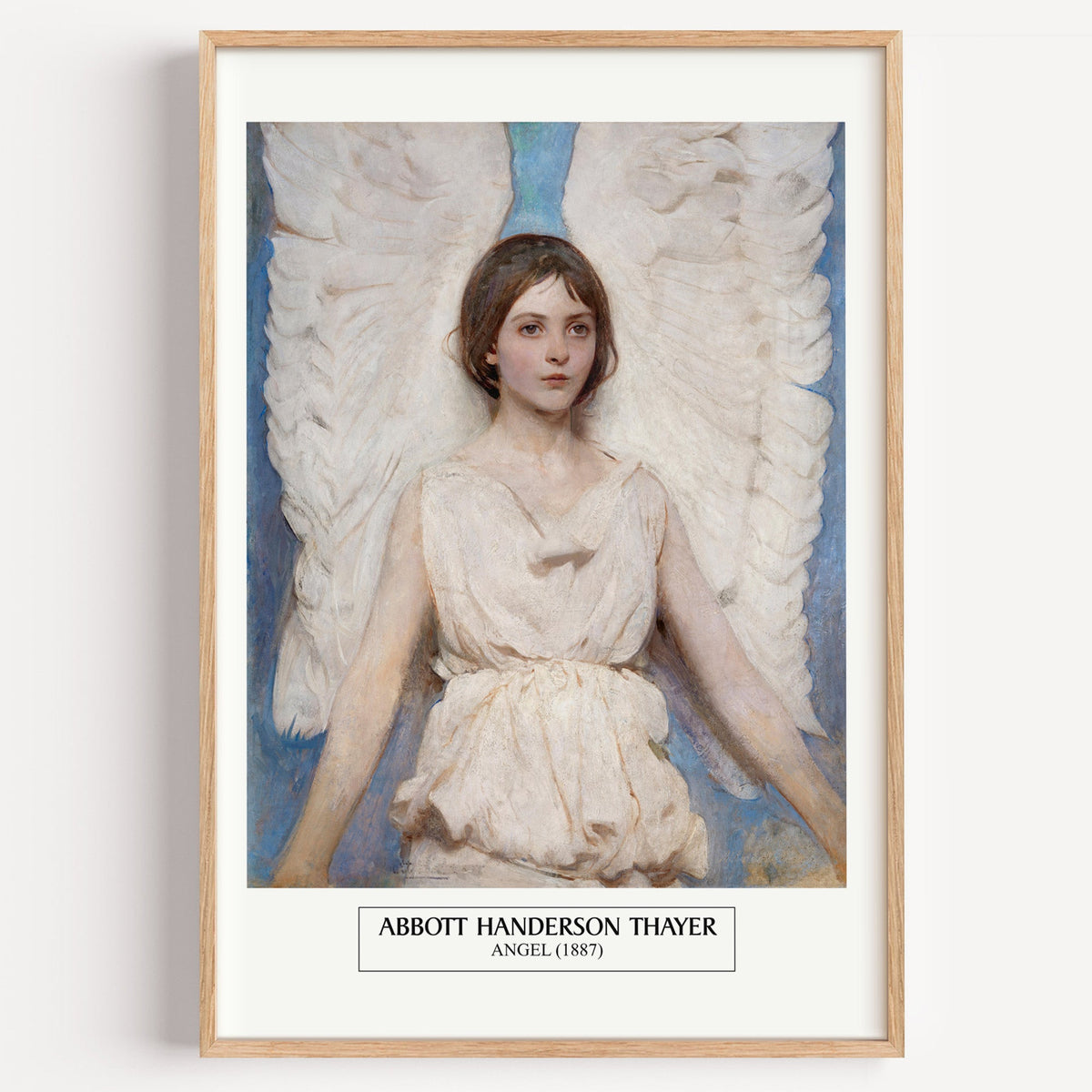 Abbott Thayer Angel print in a light oak frame on a plain white wall