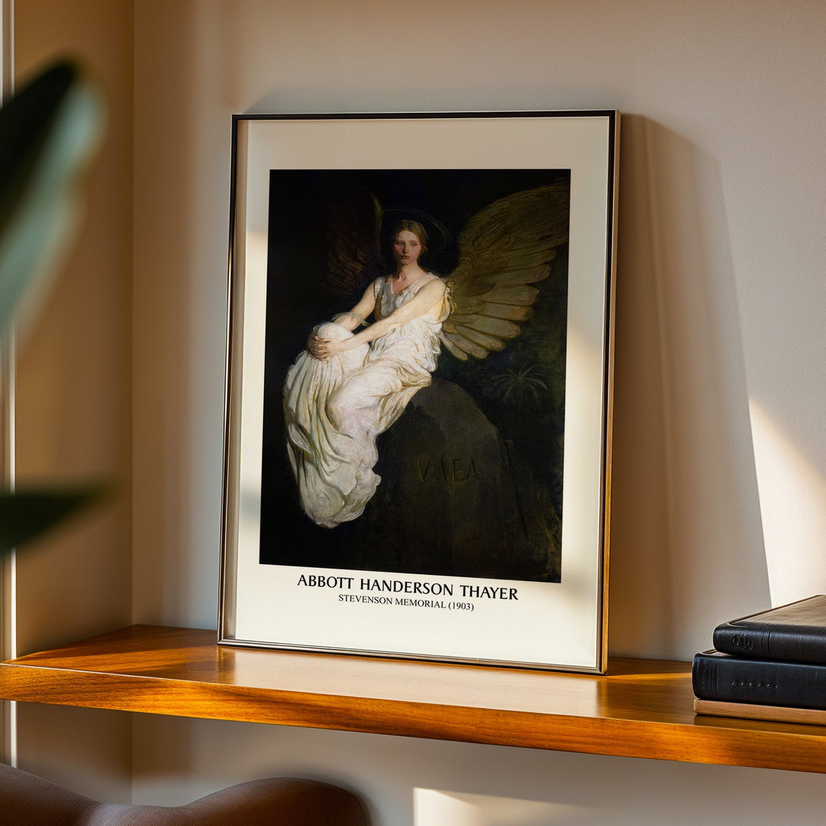 Thayer angel print in a black frame on a walnut shelf in warm evening light