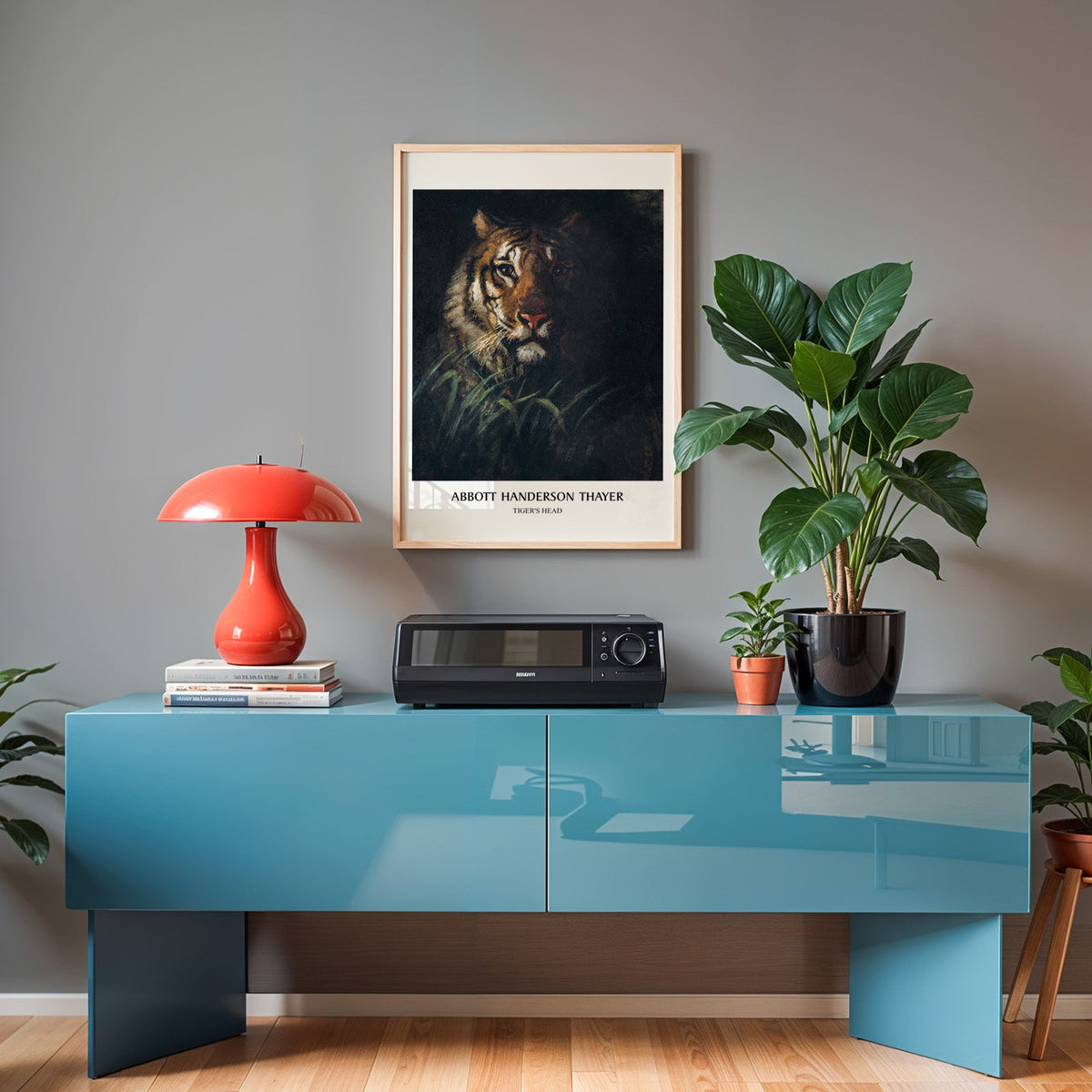 Tiger's Head poster in an oak frame above a teal sideboard with a red lamp