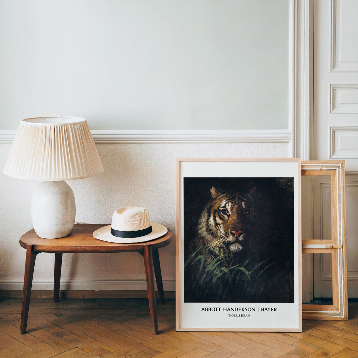 Thayer tiger poster in a light wood frame leaning by a bench and panama hat