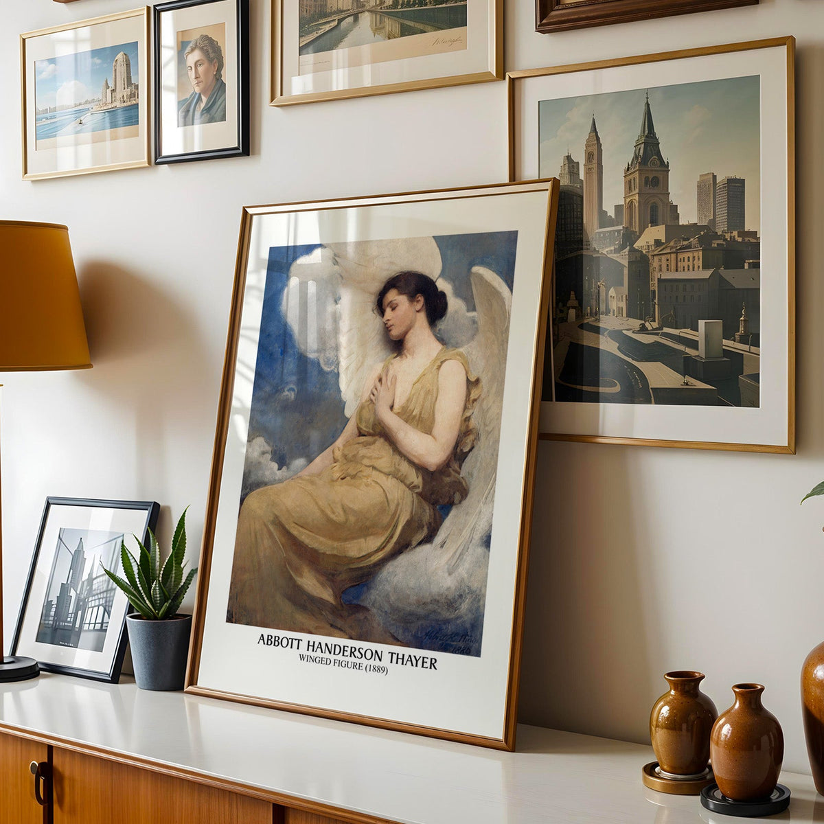 Thayer print shown in a gold frame leaning on a sideboard in a gallery wall
