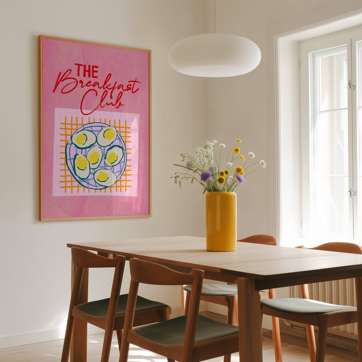 The Breakfast Club boiled eggs print in a slim oak frame above a wooden dining table under a round pendant light