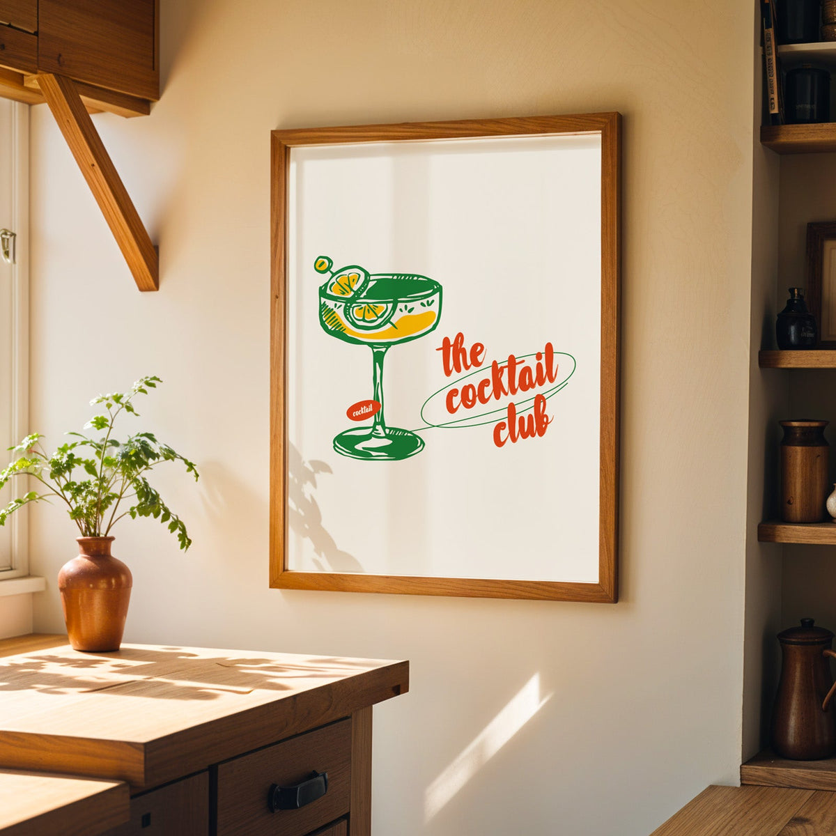 Green line coupe glass print in a wood frame on a sunlit kitchen wall beside open shelving