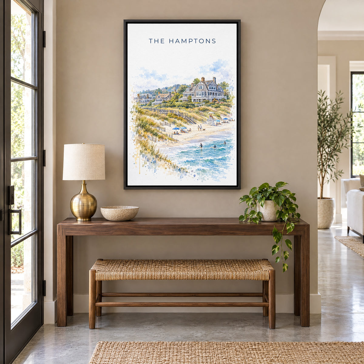 The Hamptons watercolor print as a black floater canvas above a walnut console and woven bench in an entryway
