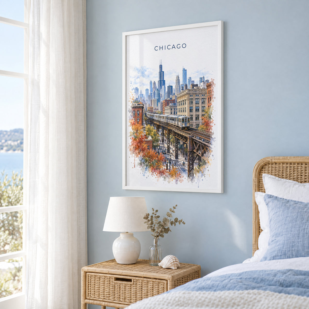 Chicago Loop watercolor print in a white frame on a pale blue wall beside a rattan bed in a coastal bedroom