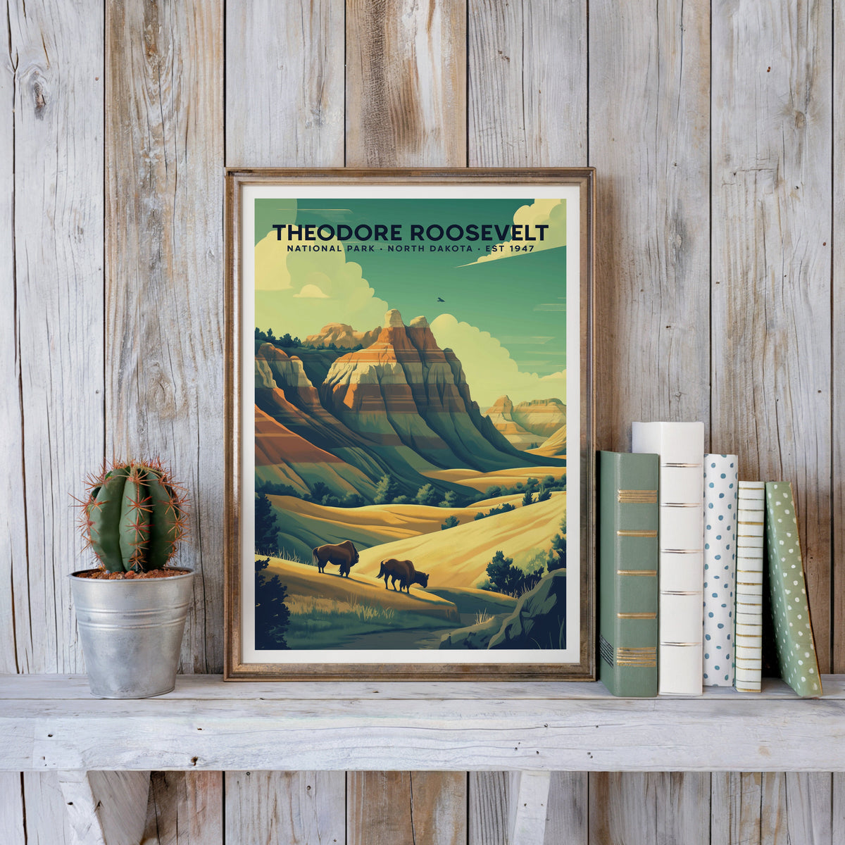 Theodore Roosevelt poster in an antique gold frame against whitewashed planks beside books and a cactus