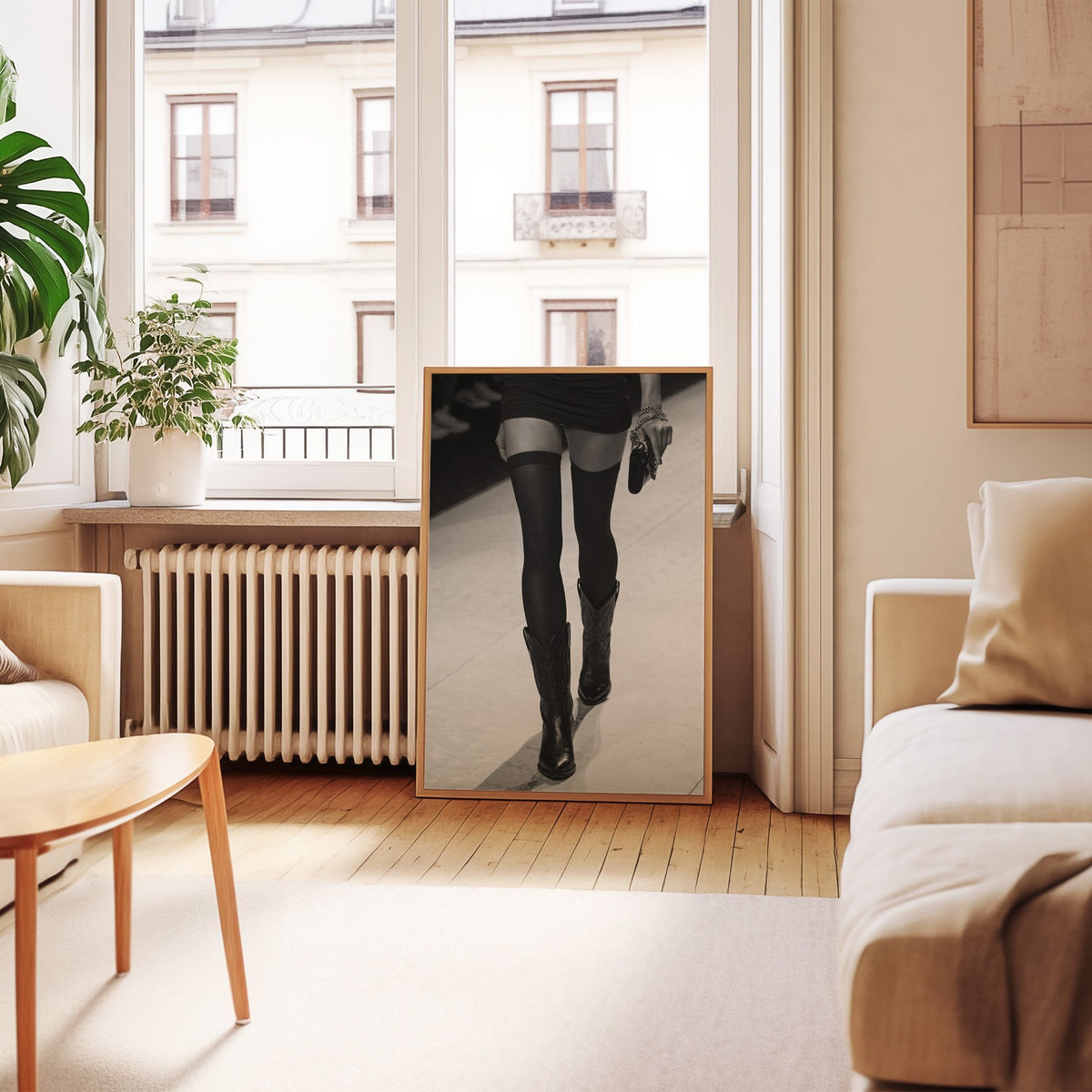 Legs in stockings and cowboy boots on runway print in an oak frame leaning by a French window in a living room