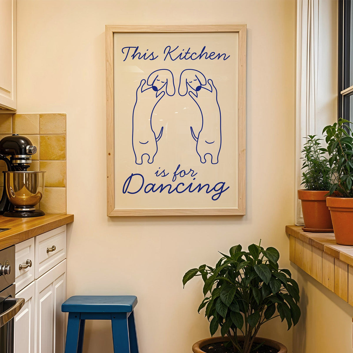 Dachshunds kitchen dancing print in a wood frame on a yellow tiled kitchen wall