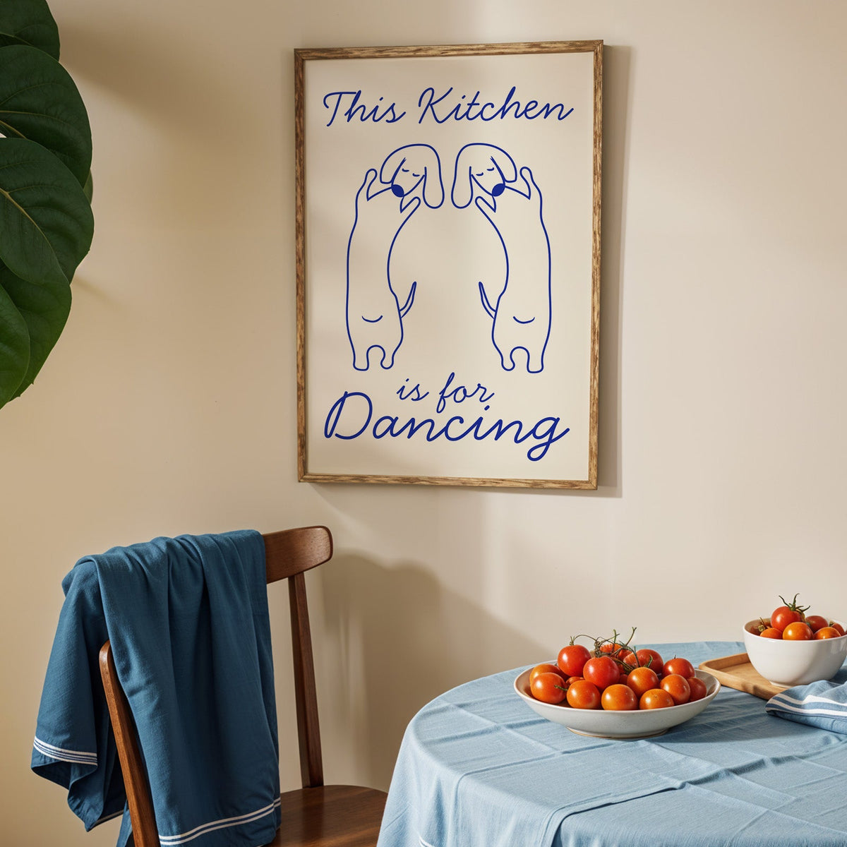Dachshunds kitchen dancing print in an oak frame above a blue linen table