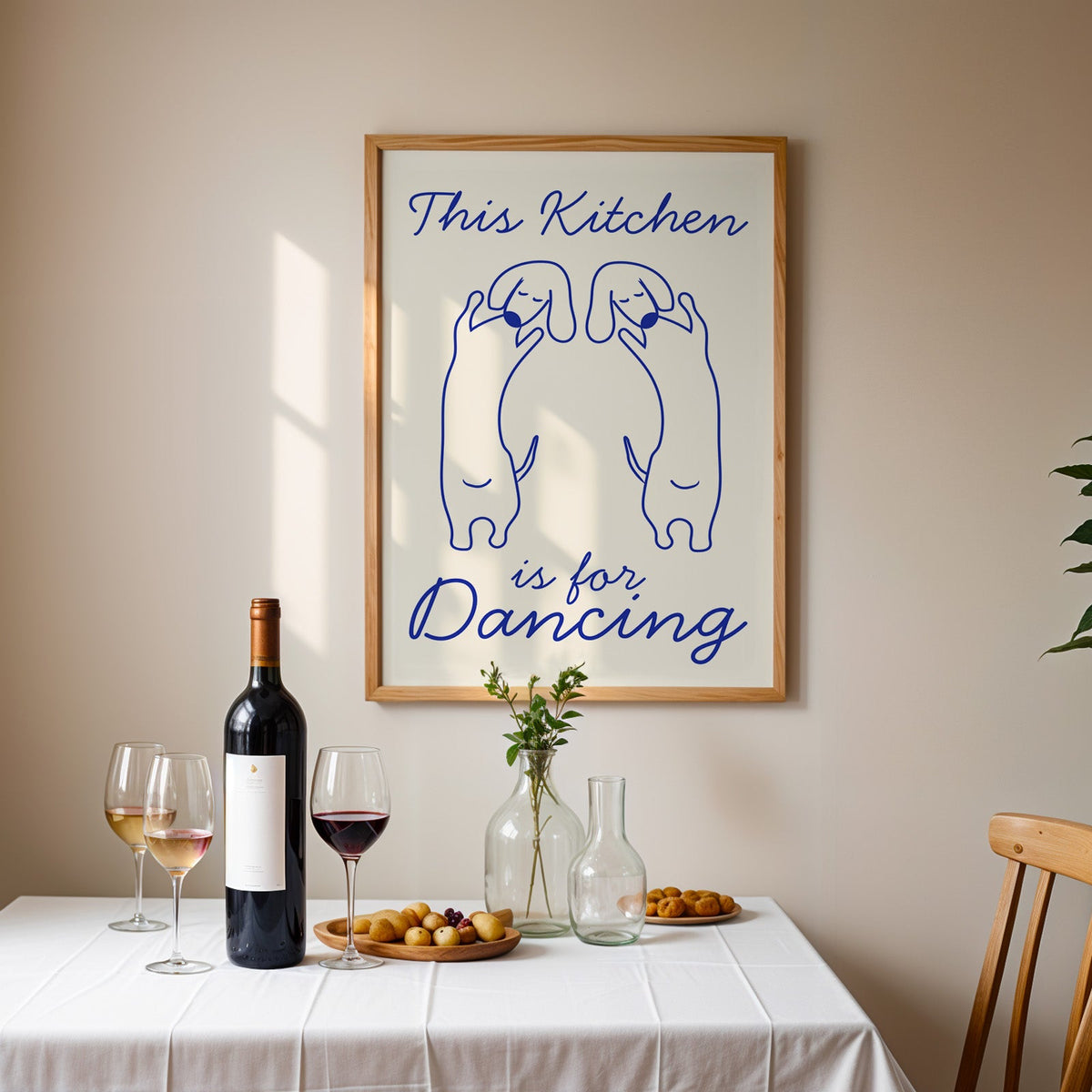 Dachshunds kitchen dancing print in an oak frame above a table laid with red wine