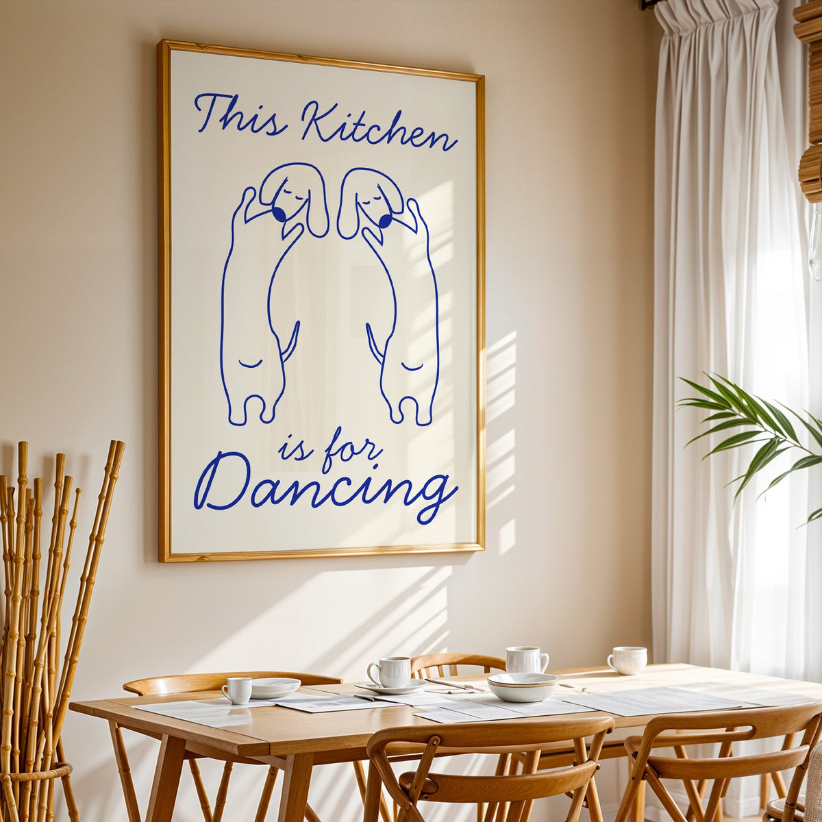 Dachshunds kitchen dancing print in a gold frame above a sunlit breakfast table