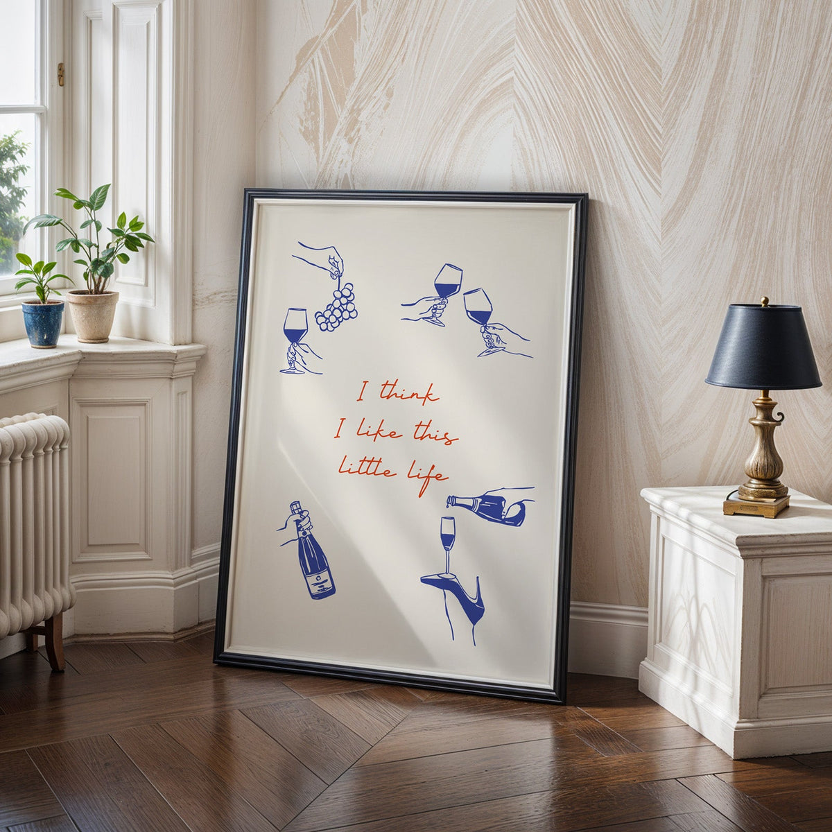 This Little Life wine print in a black frame on a dark herringbone floor