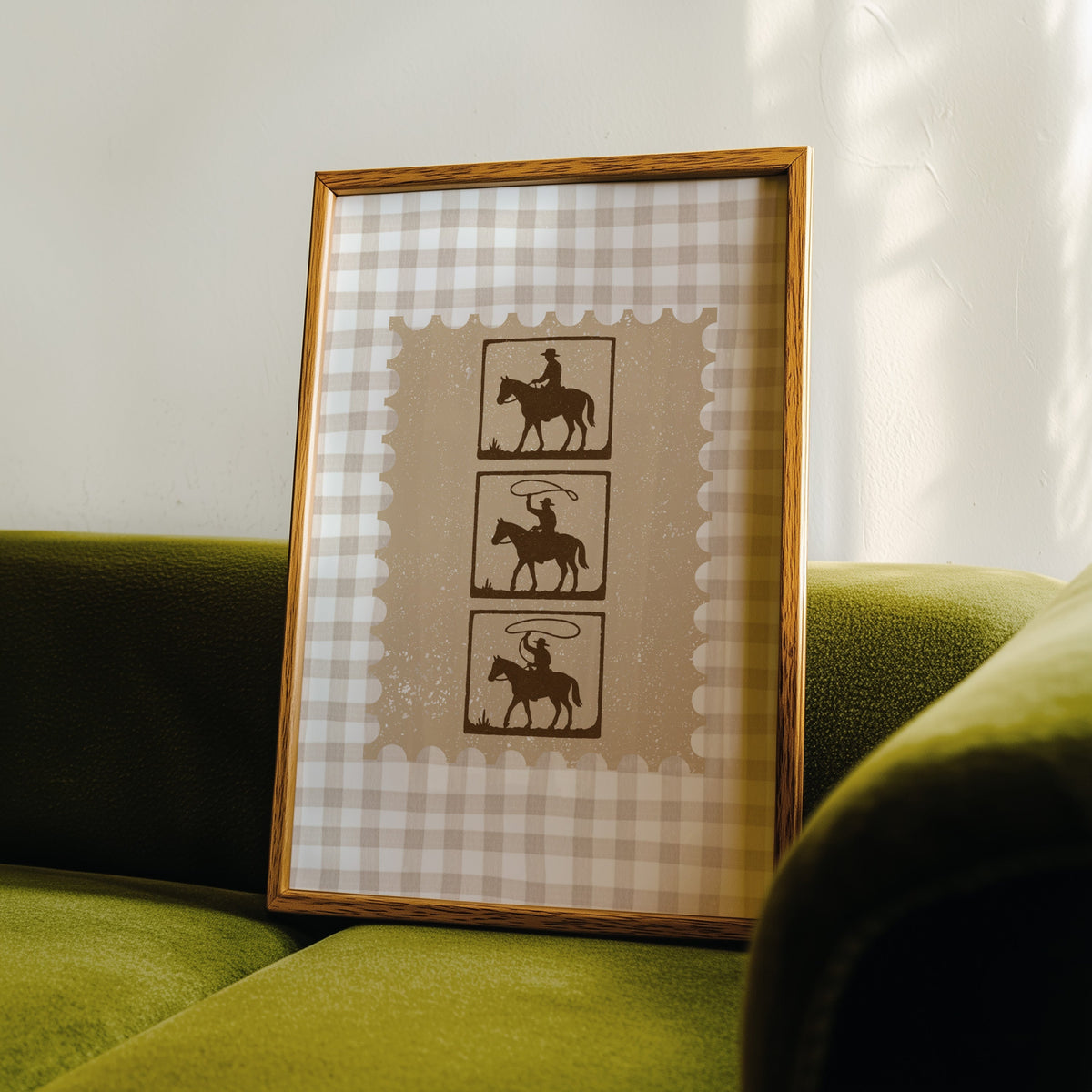 Three riders film strip print in an oak frame leaning on a green velvet sofa