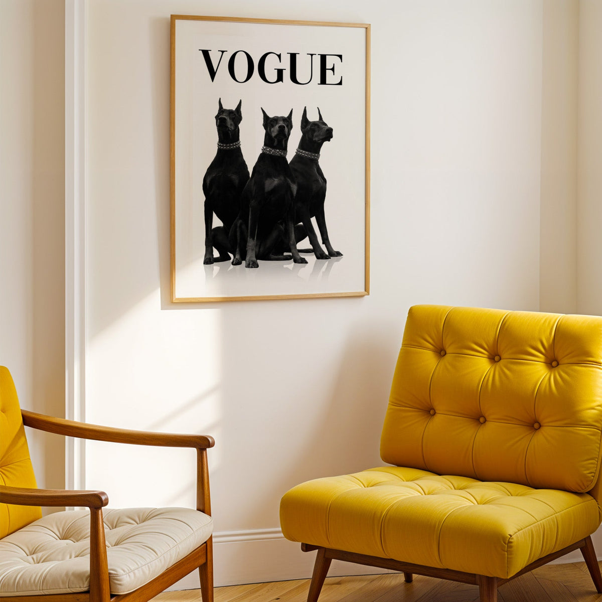 Three black Dobermans in spiked collars print shown in a gold frame above a mustard yellow tufted armchair