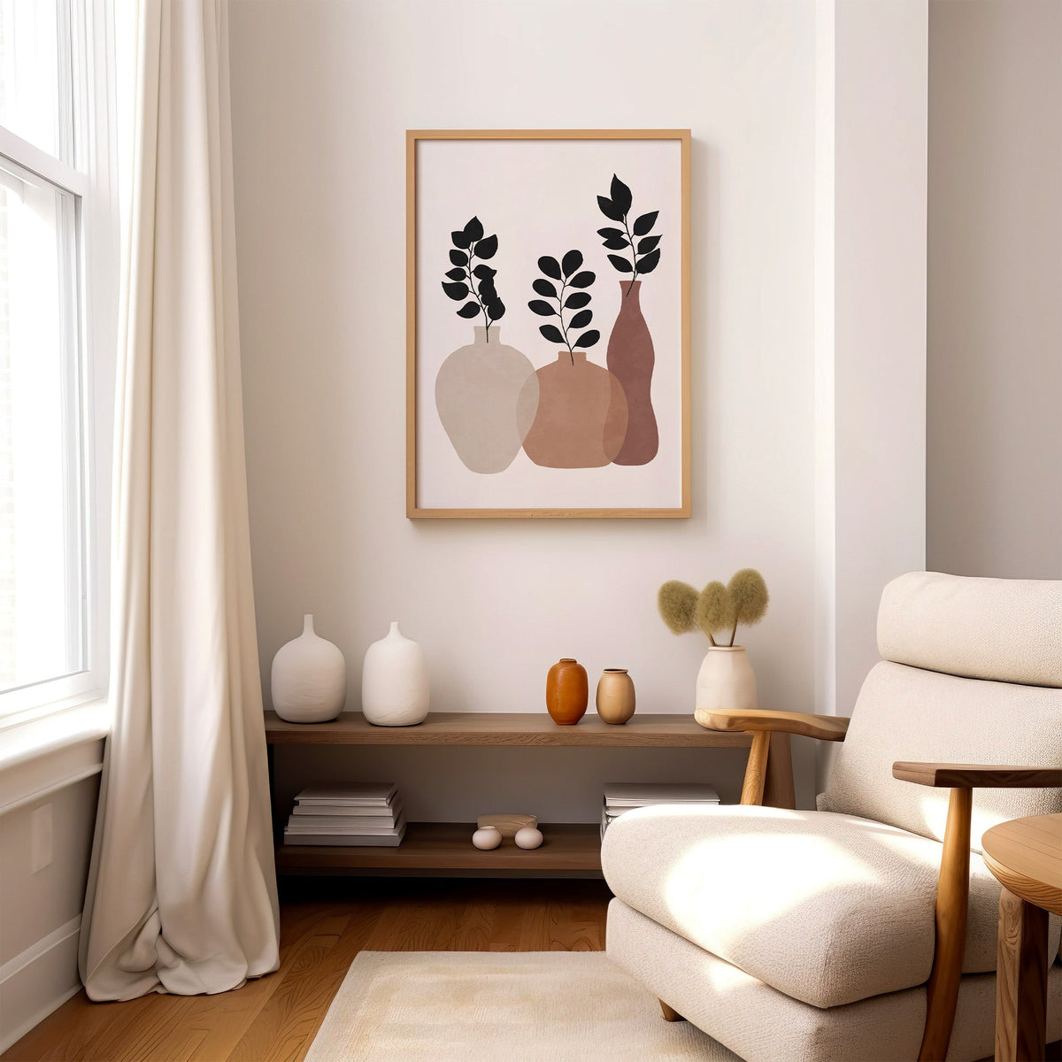Three earth tone vases with black sprigs print in an oak frame above a wood console shelf by a cream boucle armchair