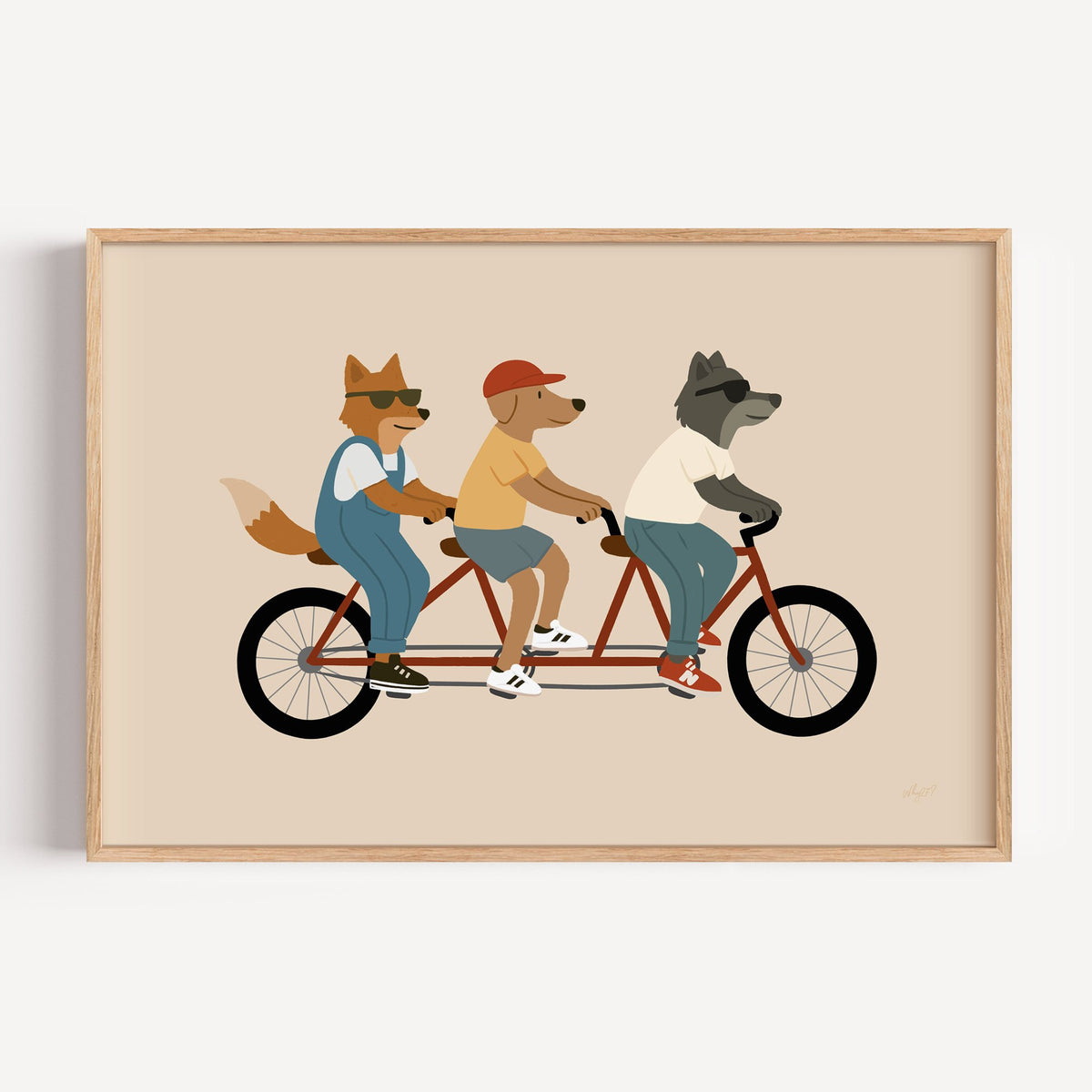 Animal friends riding tandem bike nursery print in a light oak frame on a plain white wall