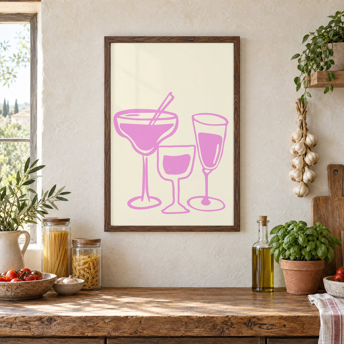 Three pink cocktail glasses linocut-style print in a walnut frame above a rustic Italian pantry counter with pasta jars, garlic and tomatoes
