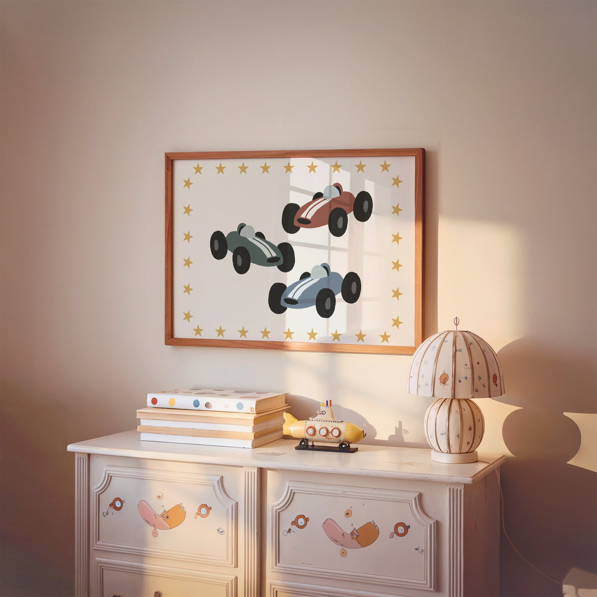 Landscape three race cars star border nursery print in a cherry wood frame above a painted dresser and lamp