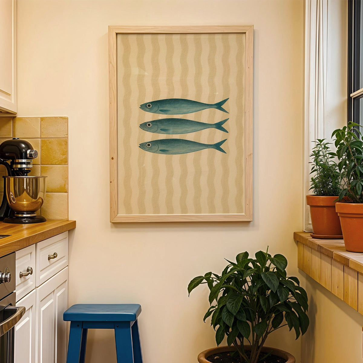 Three vintage sardines print in a wood frame on a yellow tiled kitchen wall
