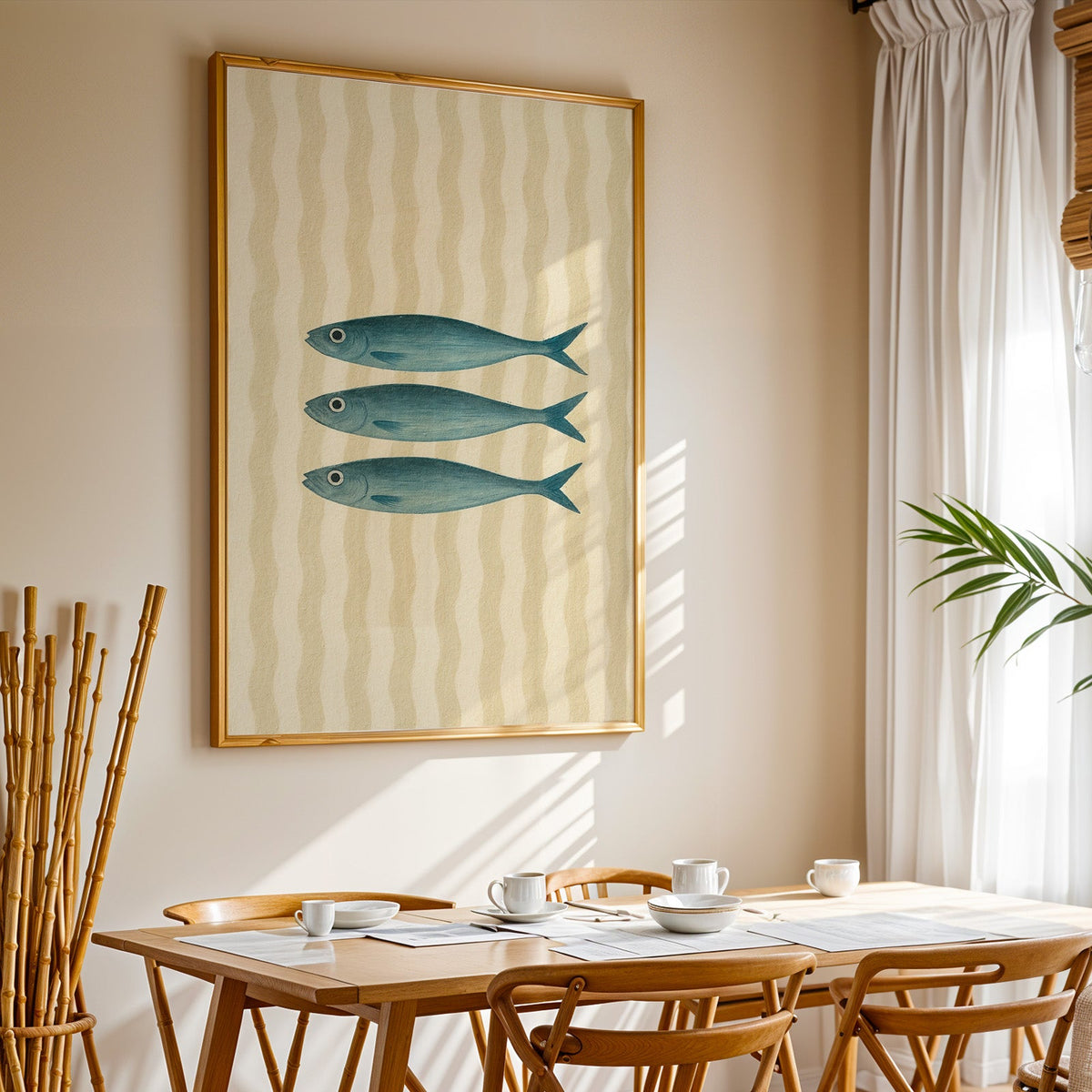 Three vintage sardines print in a gold frame above a sunlit breakfast table